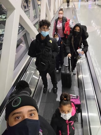 ivan and family on escalator wearing covid masks